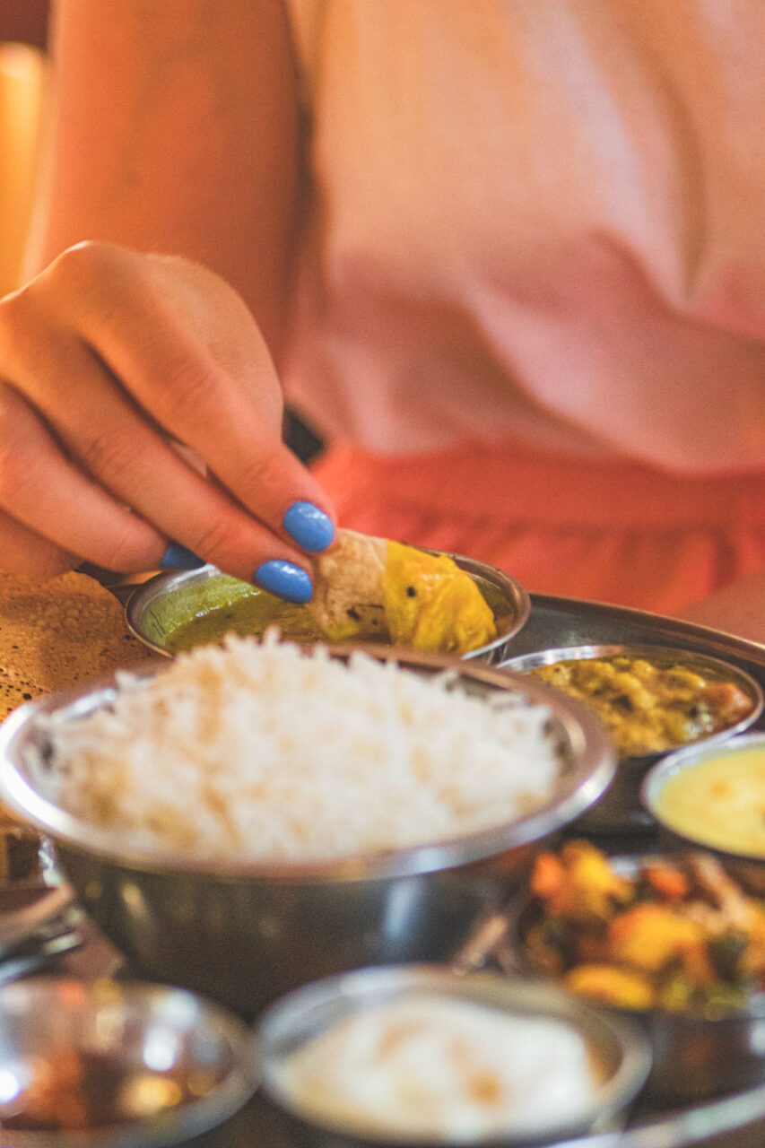 Traditional Goan thali with rice, curry, vegetables, and pickles served on a metal plate