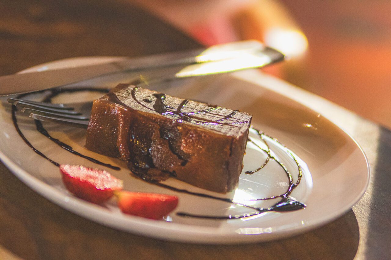 Traditional Goan dessert on a plate, drizzled with chocolate and served with strawberries