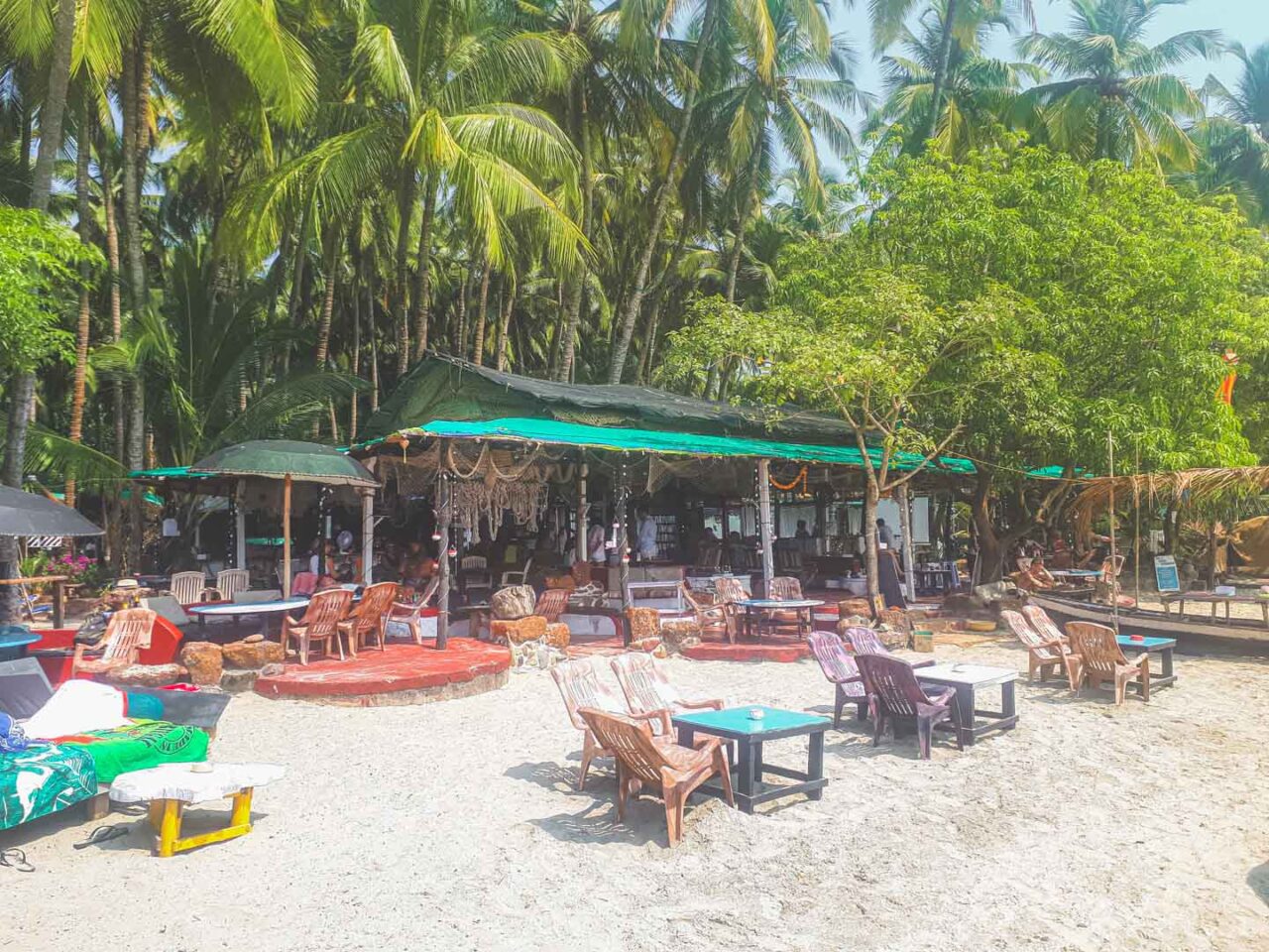 Beachfront cafés and sunbeds under coconut palms on Palolem Beach
