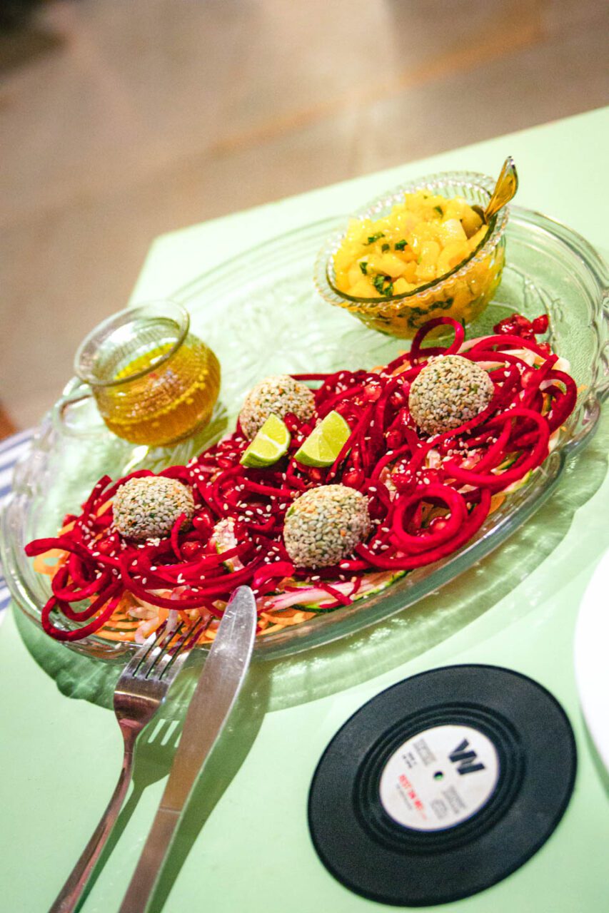 Colorful vegan plate with sesame-coated balls, raw vegetables, and mango salsa in Goa