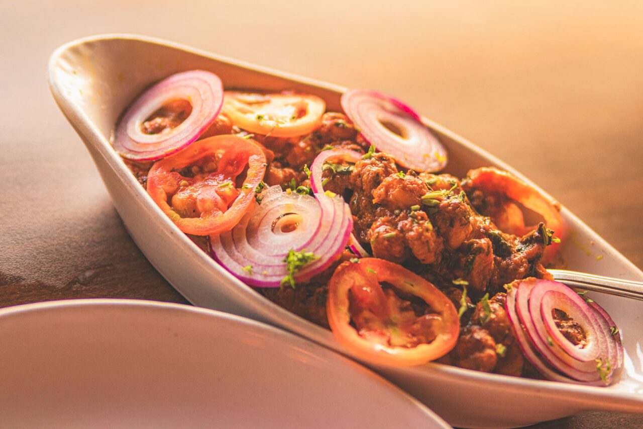 Goan seafood platter with prawns, onions, and lemon slices