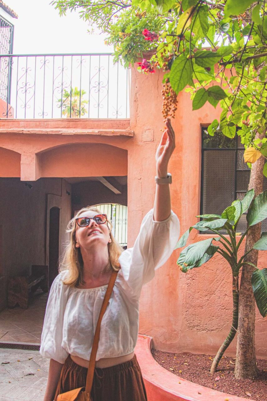 A woman touching the leaves in the patio of the boutique hotel Casa Arrona in Oaxaca, enjoying the peaceful morning atmosphere.