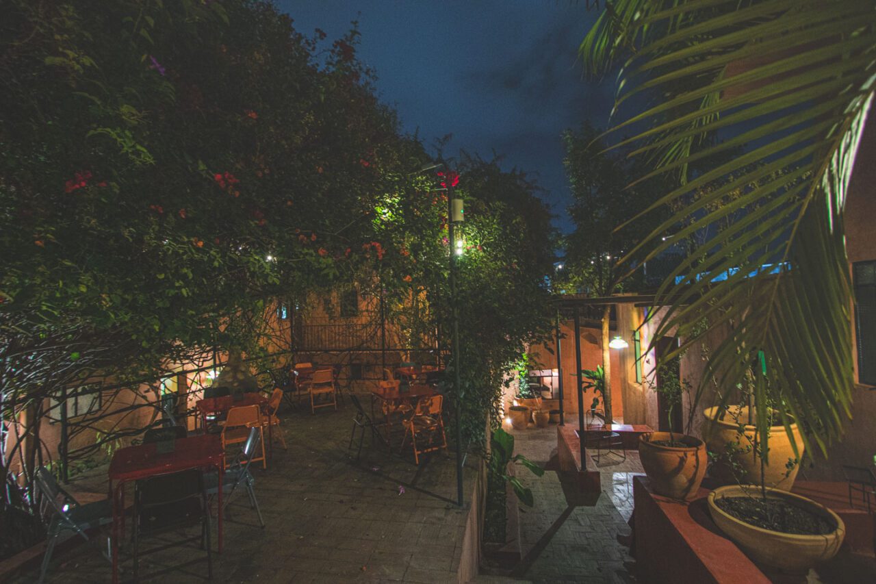 The nighttime patio of the boutique hotel Casa Arrona in Oaxaca, with plants and atmospheric lighting after dark.