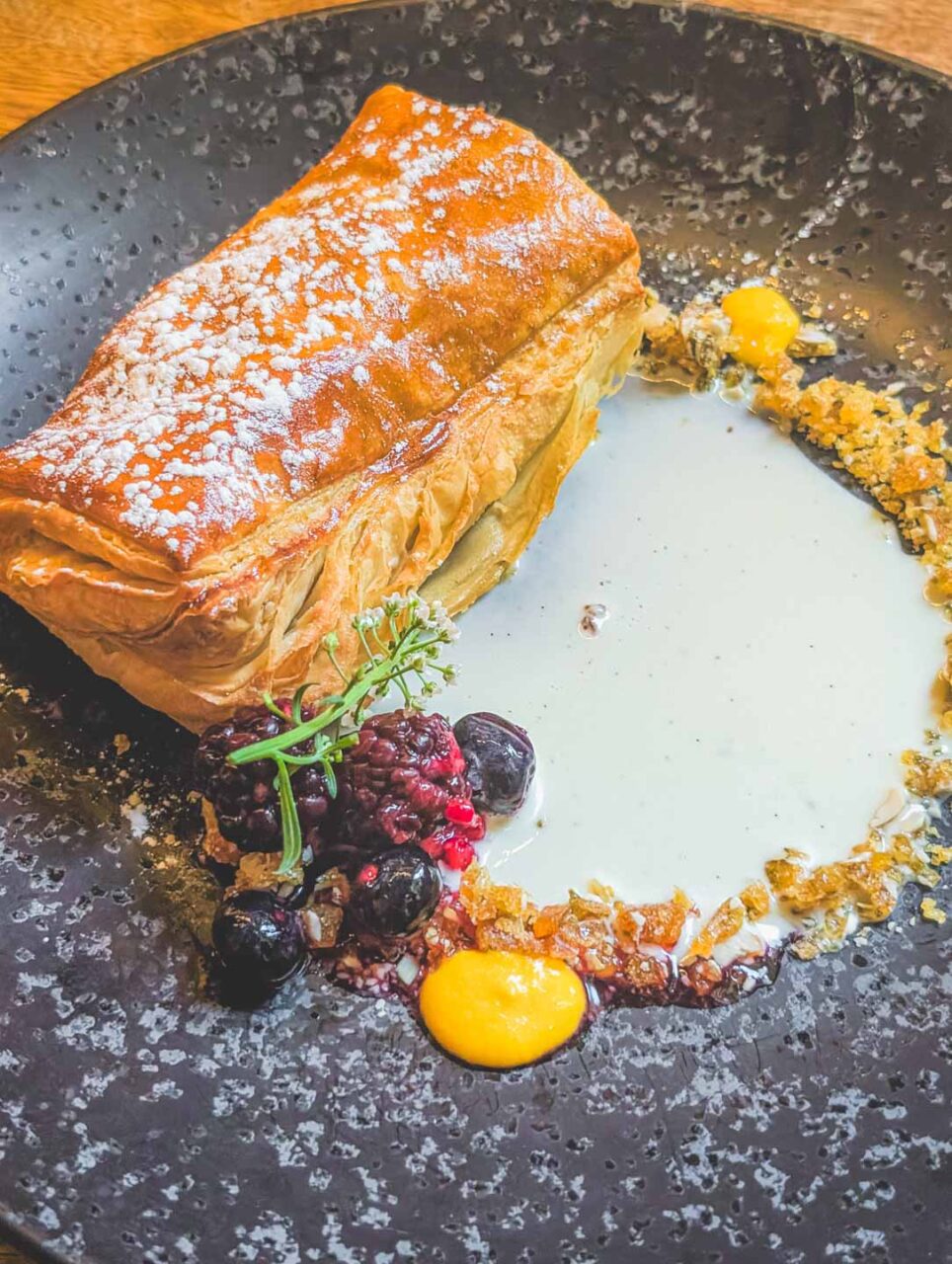 Quince empanada served at Los Danzantes restaurant in Coyoacán, Mexico City, a dessert on a black plate, a slow lunch in Mexico.