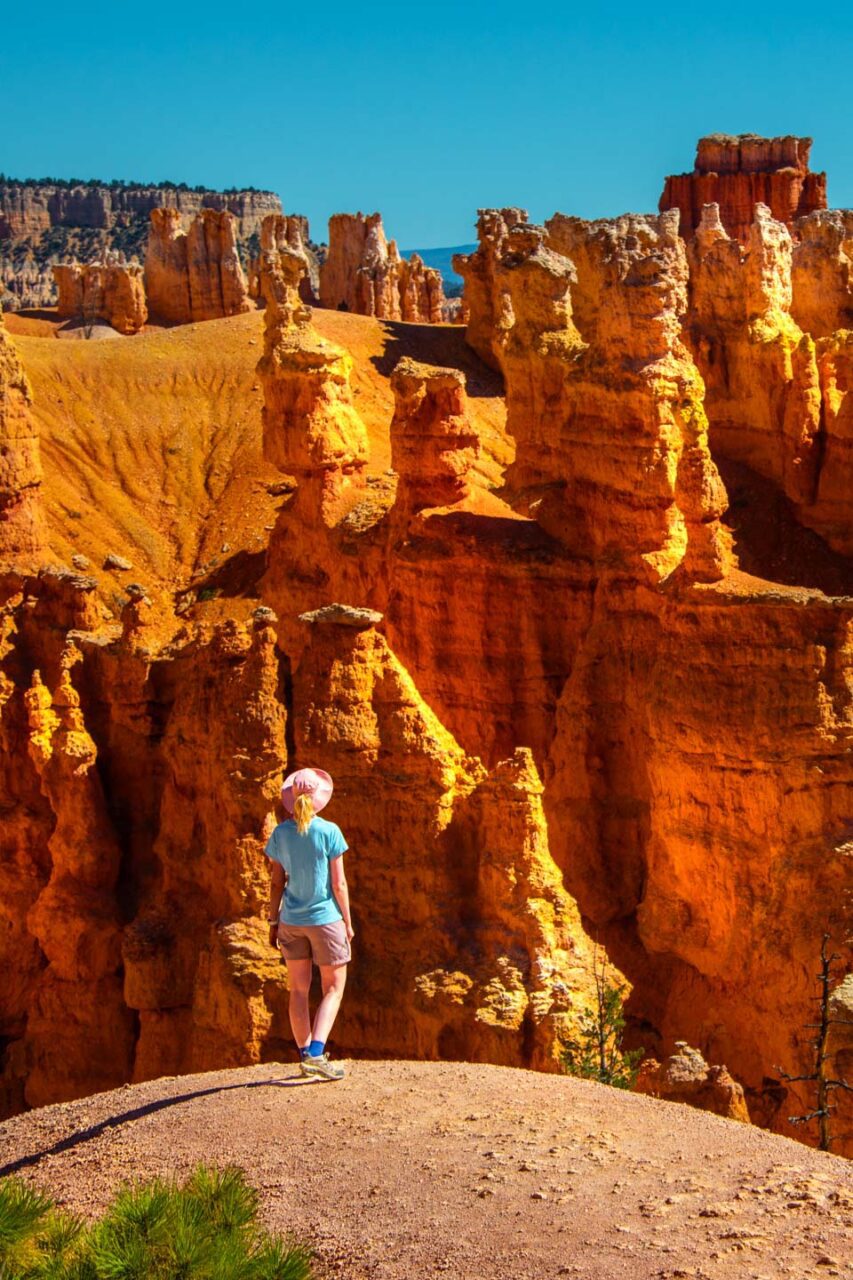 Bryce Canyon National Park w Utah – kobieta stojąca na punkcie widokowym wśród pomarańczowych formacji hoodoo, charakterystyczny krajobraz parku.