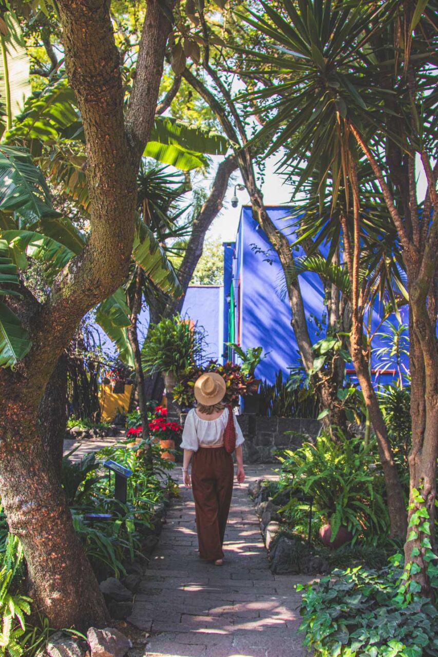 A walk through the gardens of Casa Azul in Coyoacán, Mexico City, Frida Kahlo's blue house surrounded by greenery, a peaceful and unhurried visit.