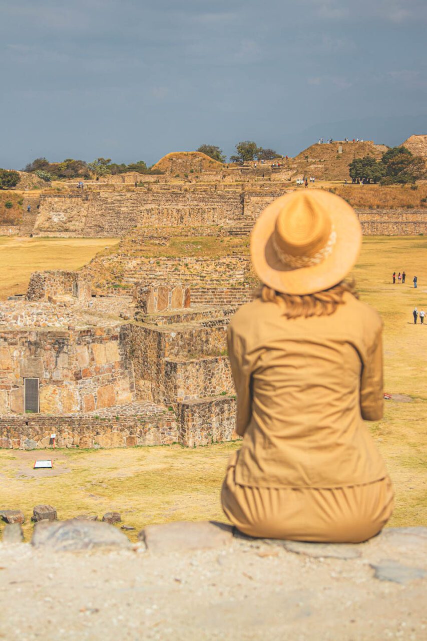 Widok na ruiny Monte Albán w Oaxaca, kobieta siedzi i patrzy na prekolumbijskie miasto