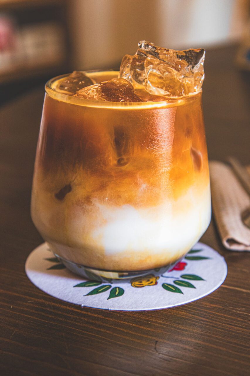 A spilled iced latte at the Once cafe in Oaxaca, a layered coffee with milk in a glass with ice.
