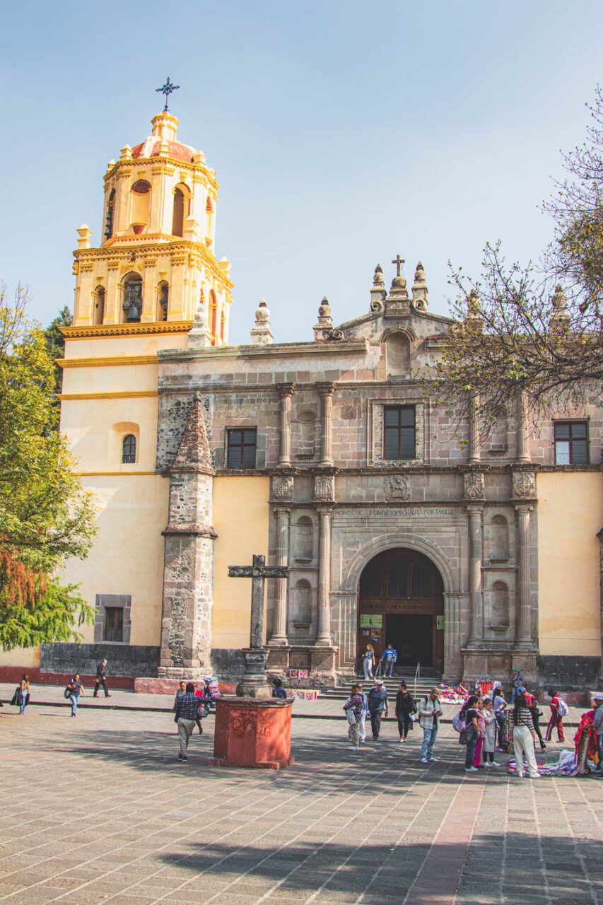 People in the square in front of the Parish of Saint John the Baptist in the Coyoacán district of Mexico City, a historic church and a peaceful atmosphere of the place.