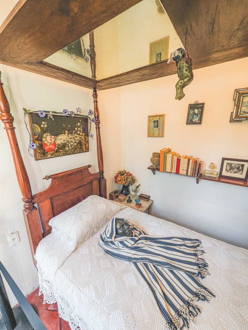 Frida Kahlo's bedroom in Casa Azul in Coyoacán, Mexico City, featuring a wooden four-poster bed and the artist's personal belongings, inside the Frida Kahlo Museum.