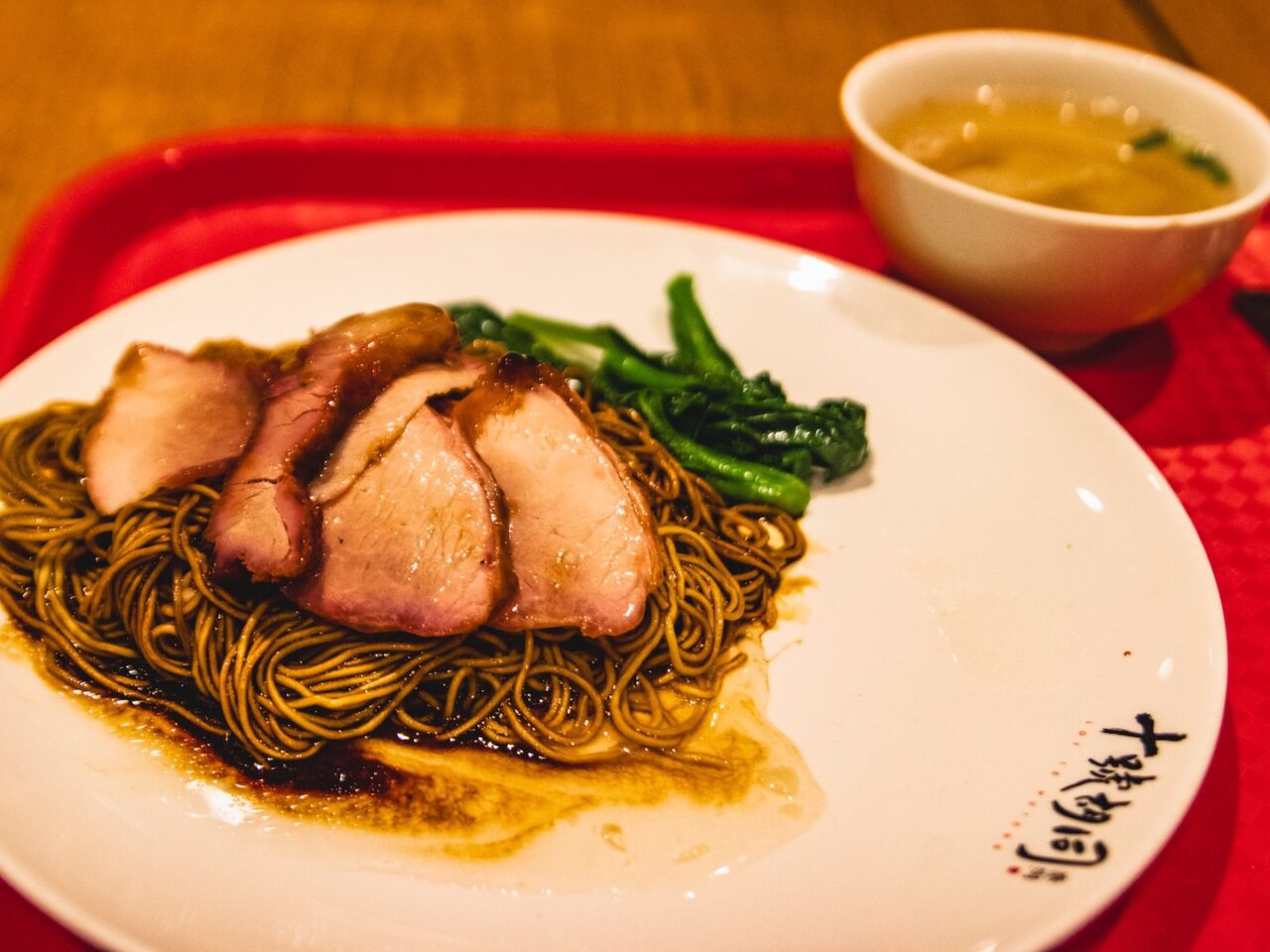 Makaron z pieczoną wieprzowiną char siu i zielonymi warzywami podany w Lot 10 Hutong w Kuala Lumpur.