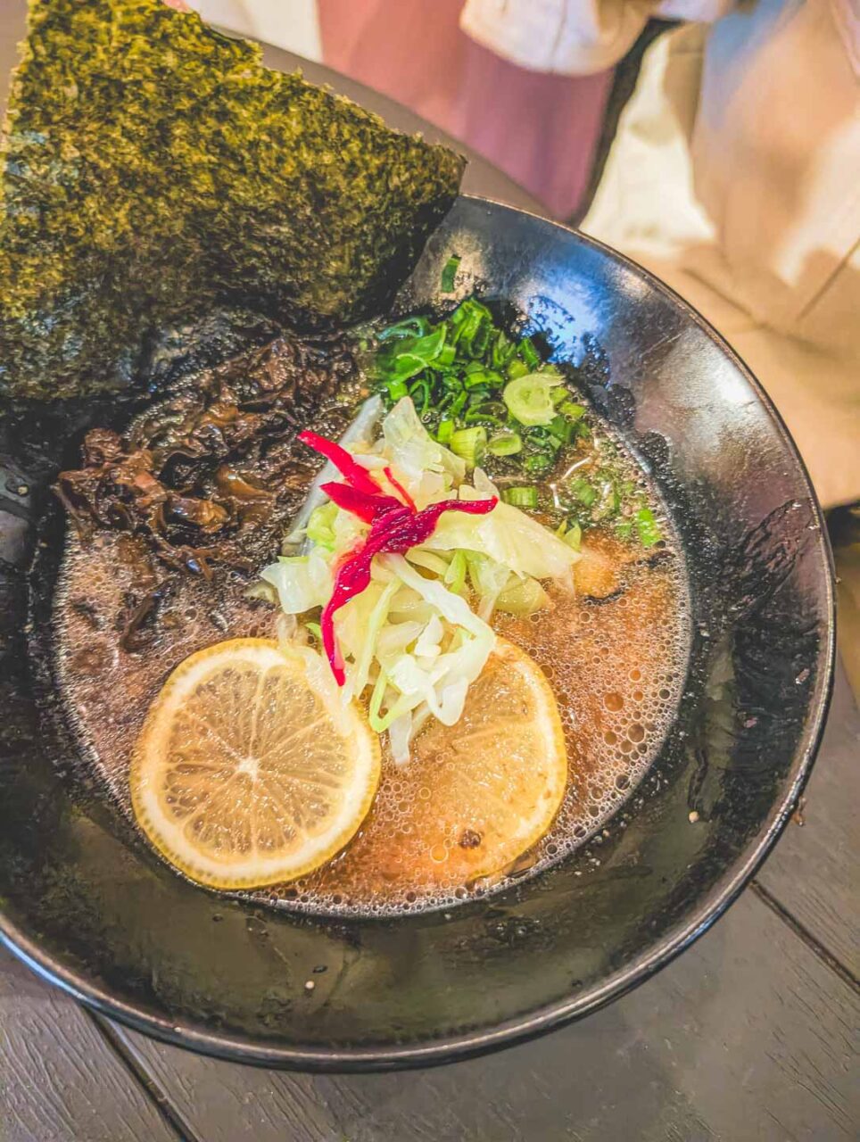 Wegański ramen podany w restauracji Mei w Mexico City, miska ramenu z cytryną, algami i warzywami, wieczorna kolacja w mieście