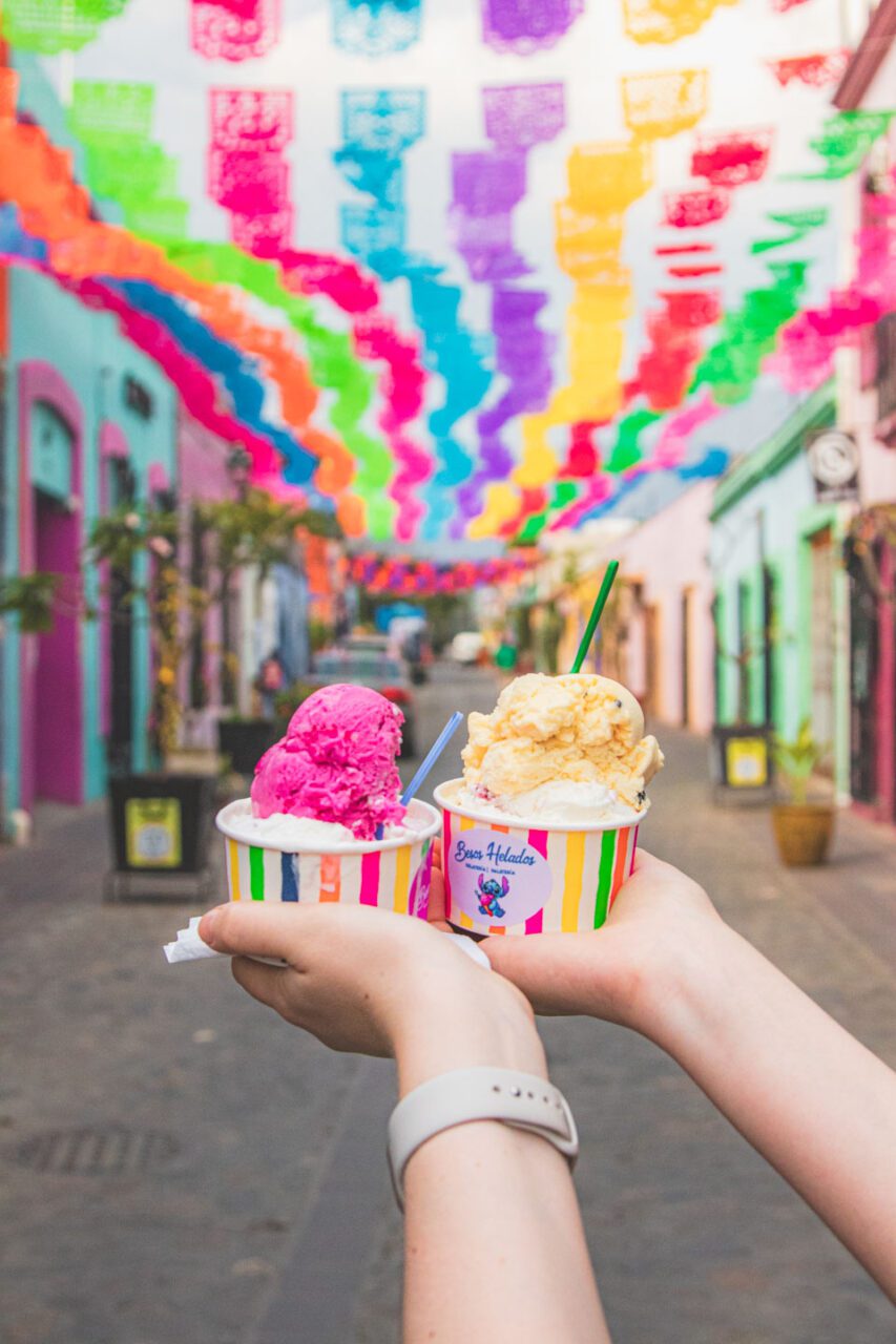 Artisan ice cream held in hands on a colorful street in Oaxaca, Mexico.