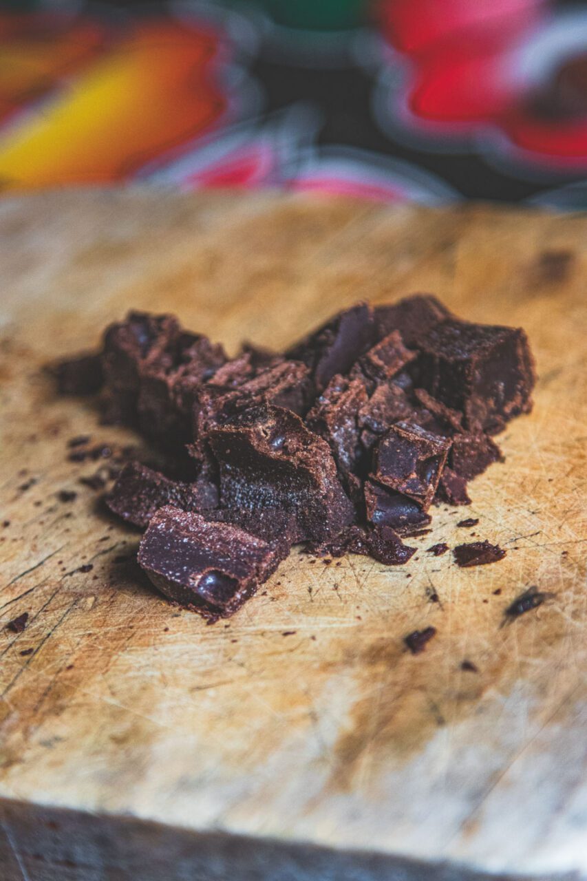 Handmade chocolate bar from Oaxaca, cut into pieces on a wooden board.