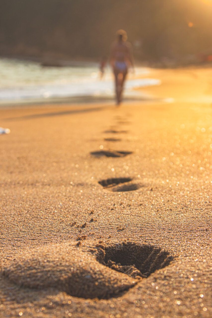 Footprints in the sand as a symbol of slow travel