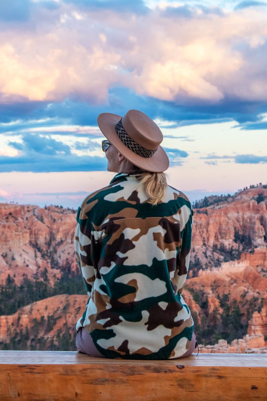 woman sitting overlooking Bryce Canyon amphitheater Utah scenic viewpoint