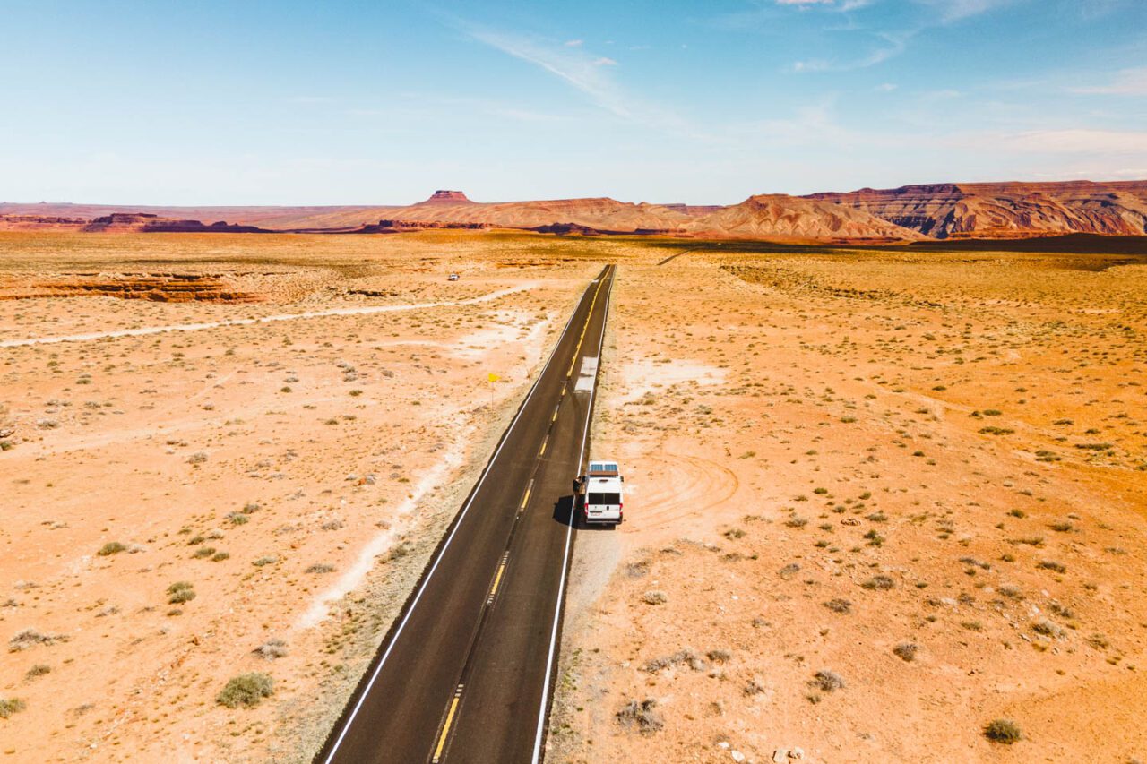 campervan driving on scenic road to Goosenecks State Park Utah desert landscape