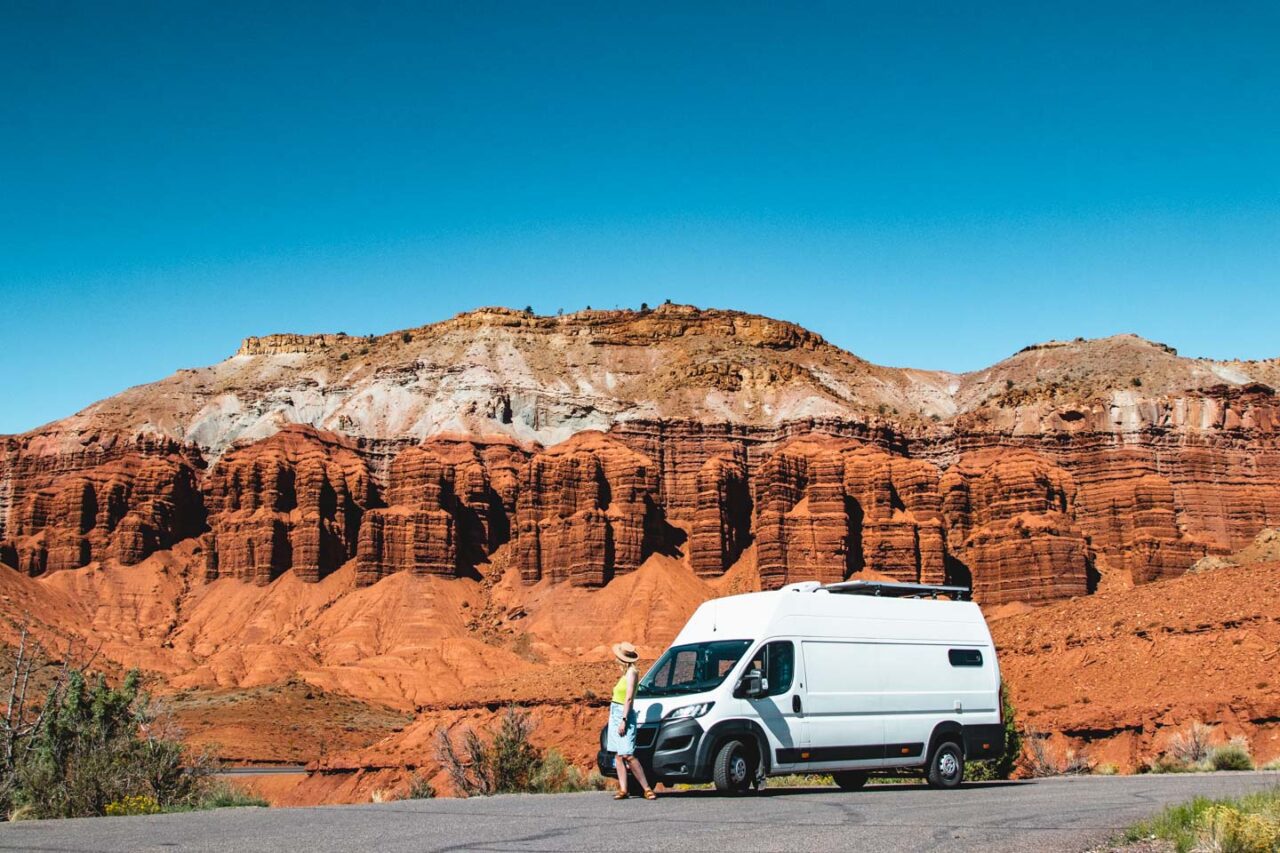 woman standing by campervan in red rock landscape Sedona Arizona road trip