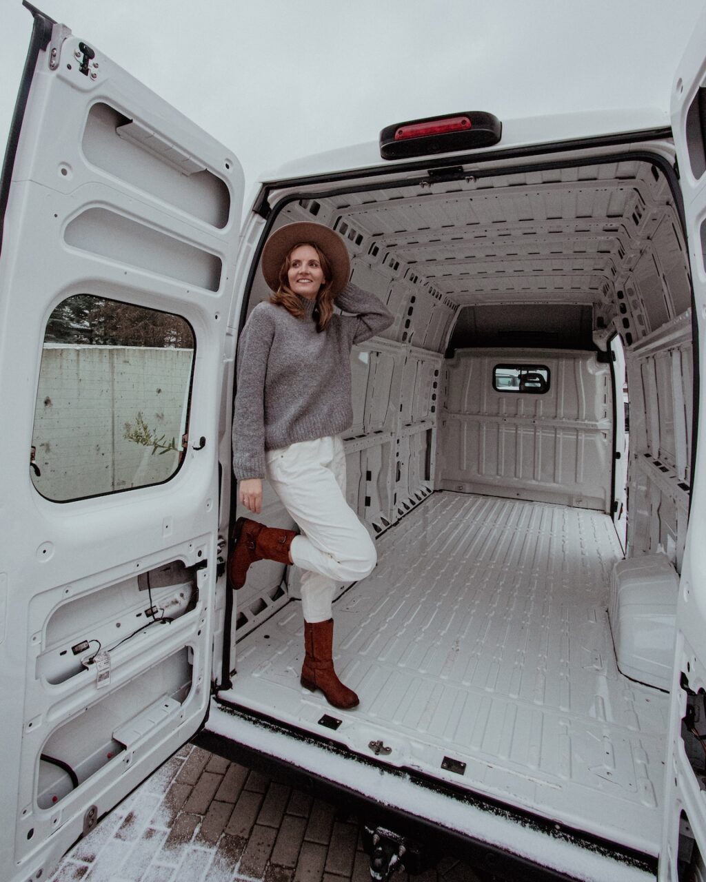 I’m standing in an empty van before the conversion-the start of a DIY camper build.