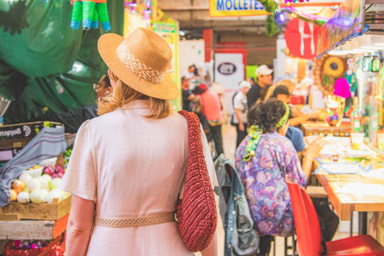 A woman in a crowded market while traveling, and the feeling of FOMO while sightseeing.