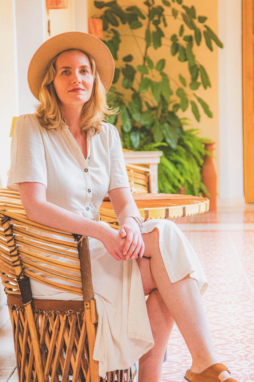 A woman sitting in a tranquil interior while traveling-a moment of unhurried pause.