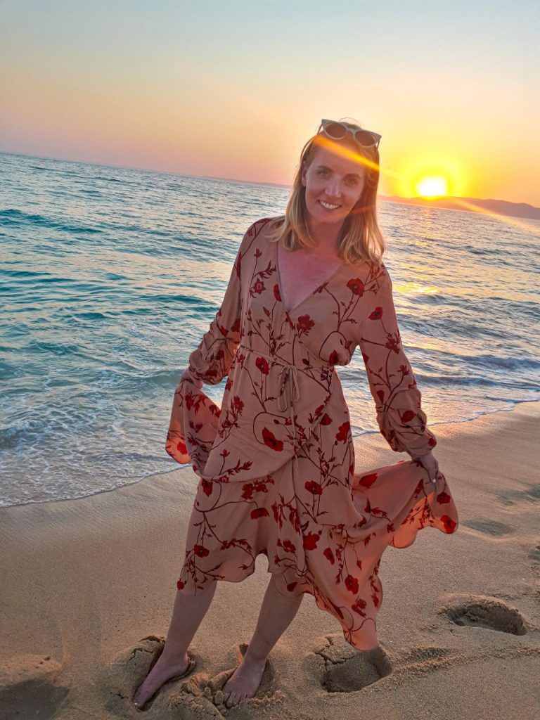 Woman on the beach in Comportu, Portugal during sunset