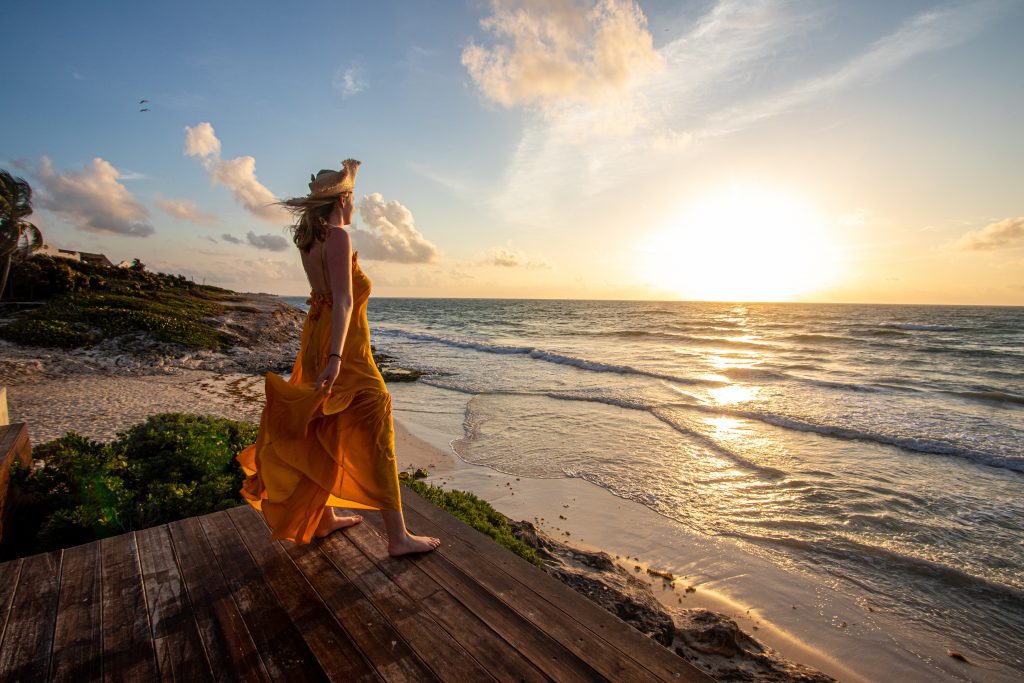 Woman admiring sunrise over the sea in Habitas Tulum, Quintana Roo, Mexico