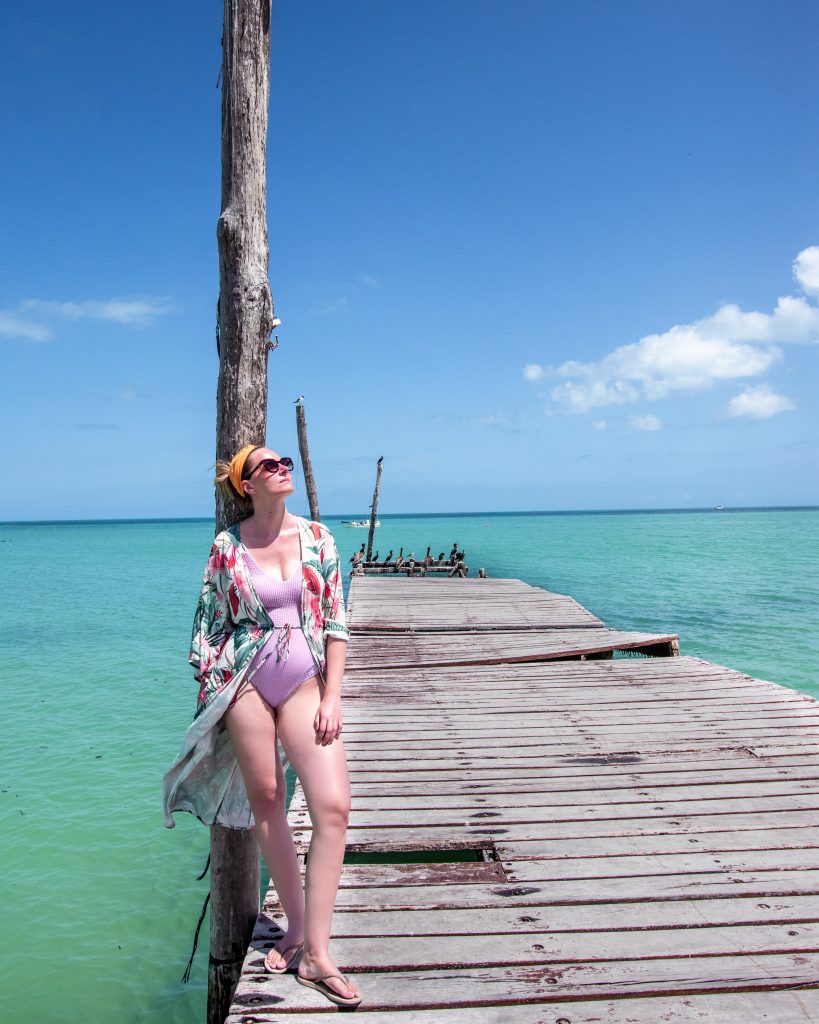 Woman sitting on the pier on Isla Holbox, Quintana Roo, Mexico