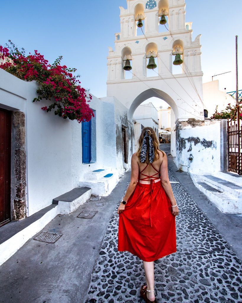 Woman in red dress in Megalochori, Santorini, Greece