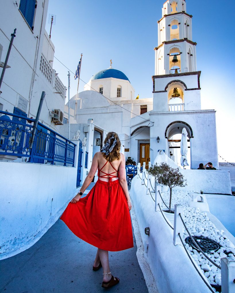 Woman in red dress in Pyrgos, Santorini, Greece