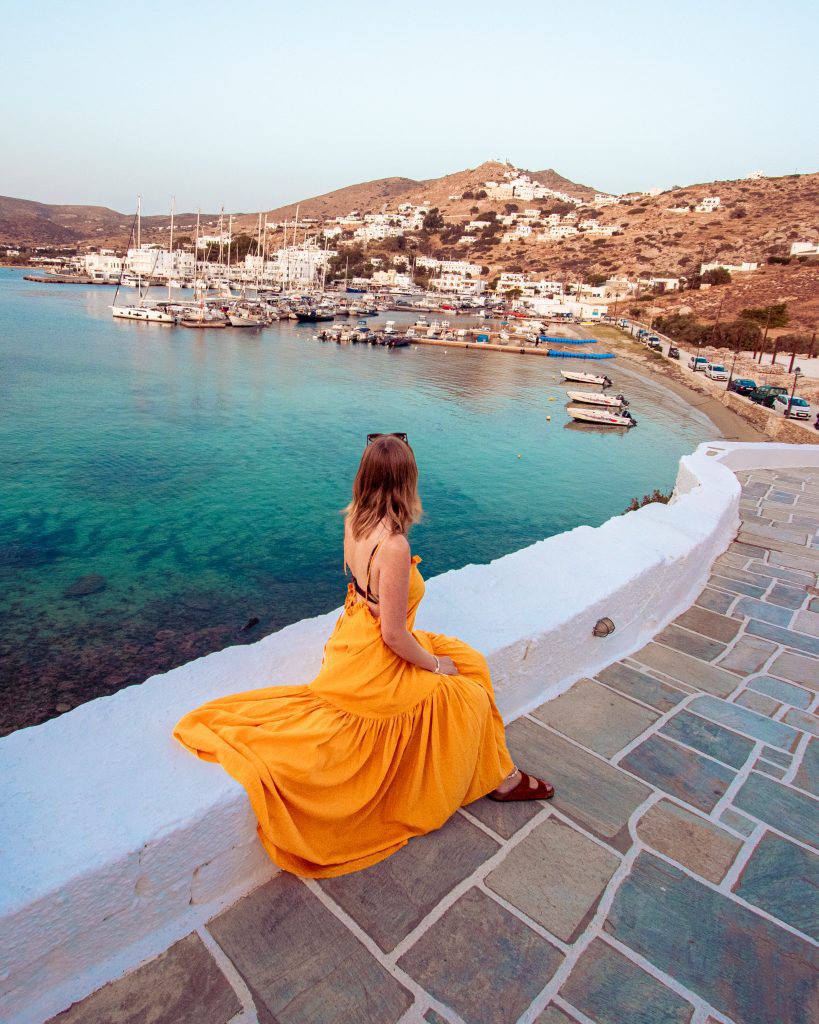 Woman in yellow dress on the background of the sea in Ios Port, Greece