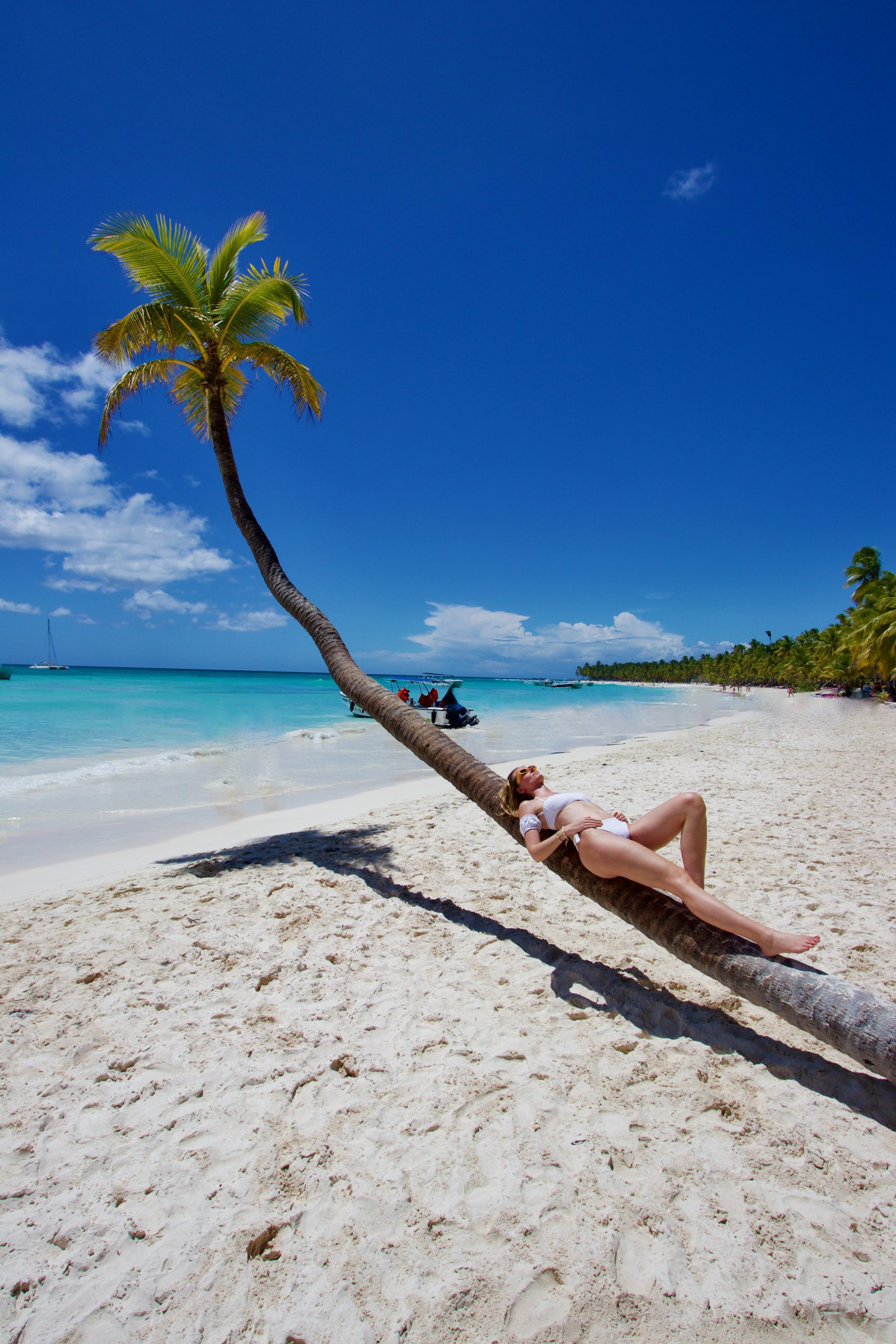 Woman lying on a palm tree in Isla Saona, Dominican Republic
