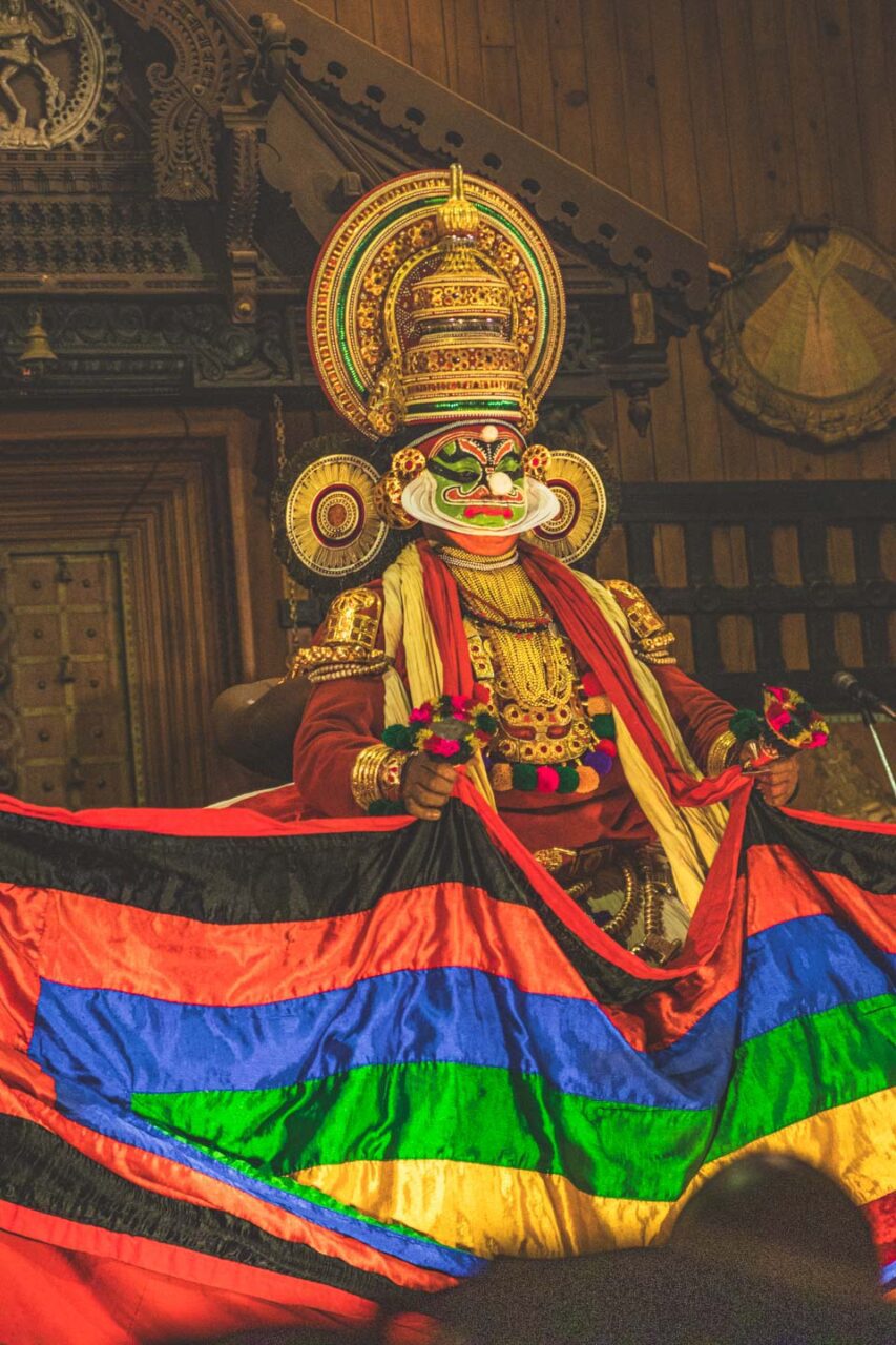 Tradycyjny tancerz Kathakali w bogatym kostiumie i makijażu, podczas spektaklu w Koczin w Kerali – symbol sztuki opowiadanej gestem, ruchem i barwą.