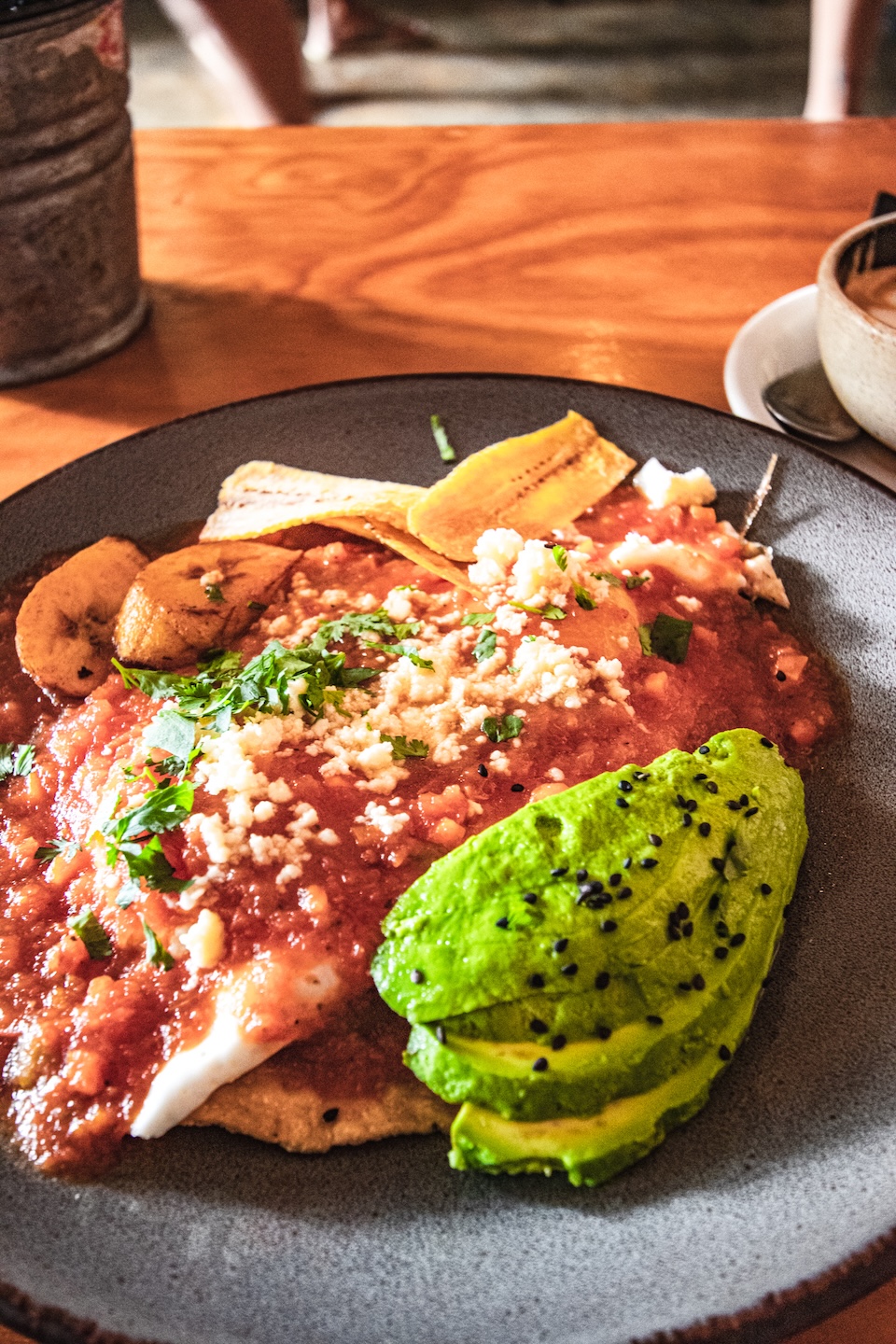 Talerz z huevos rancheros – jajkami na tortilli kukurydzianej, polanymi sosem pomidorowym, z awokado, smażonym platanem i posypką z sera w kawiarni Del Cielo w Tulum.