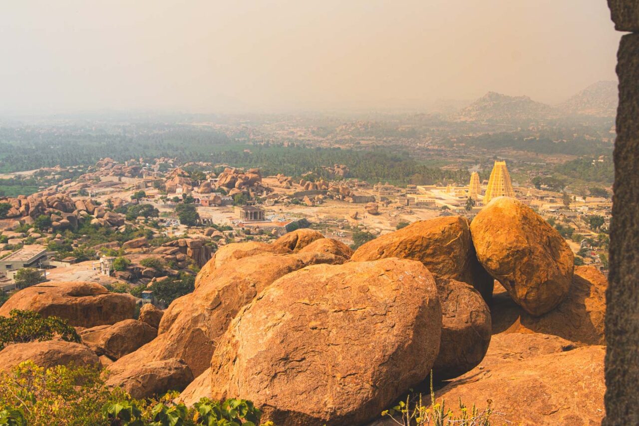 Panorama Hampi widziana ze wzgórza Matanga – czerwone skały na pierwszym planie, w tle świątynia Vir