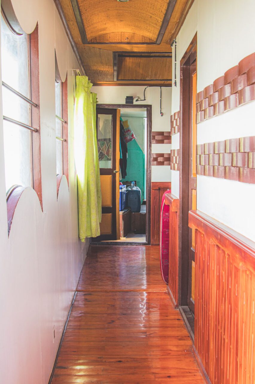 A corridor on our boat. Narrow, wooden, with a lemon-patterned curtain.