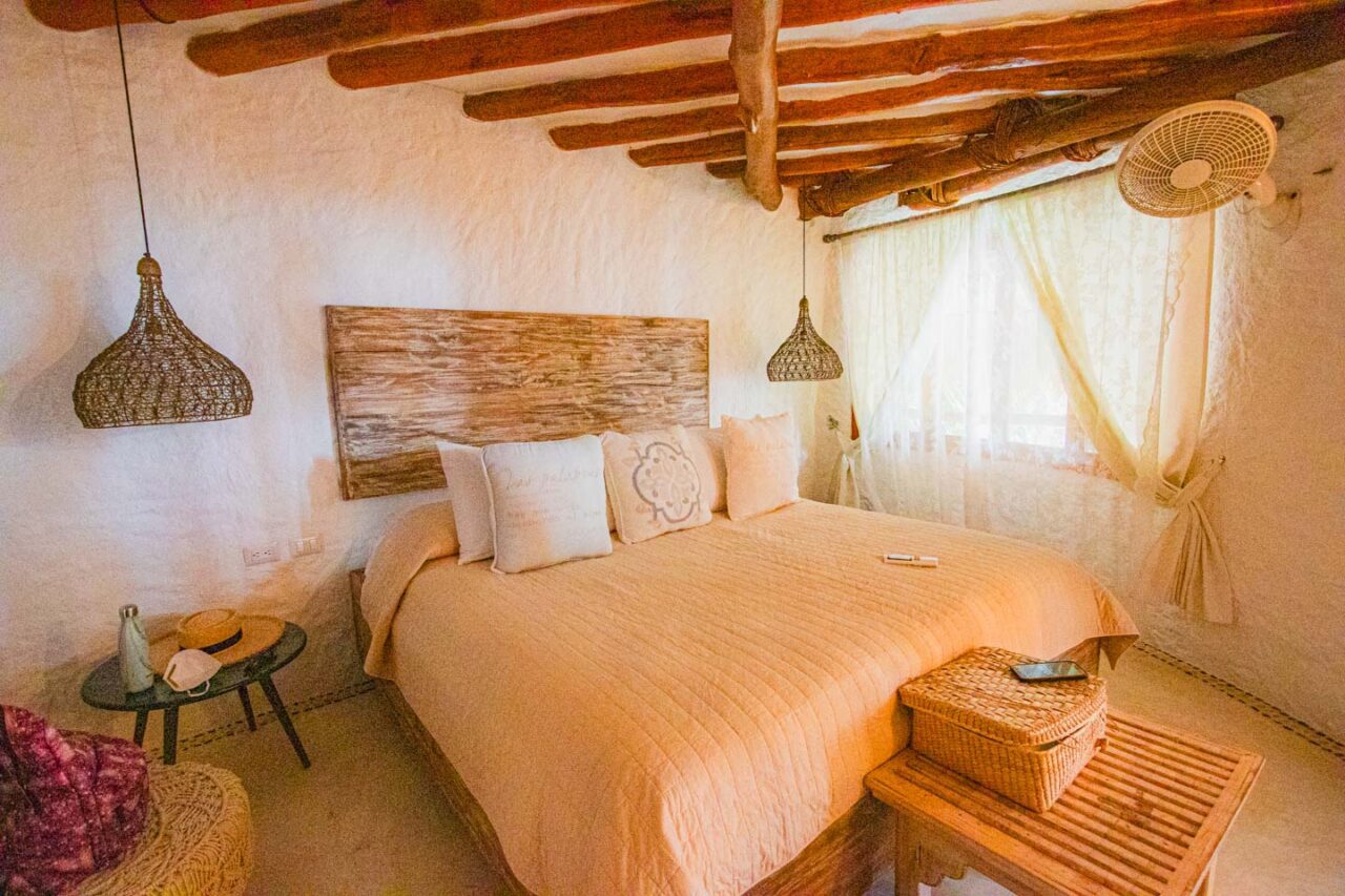 Pokój w Casa Las Tortugas na Isla Holbox - boho wnętrze z drewnianym sufitem, wiklinowymi lampami i naturalnym światłem
