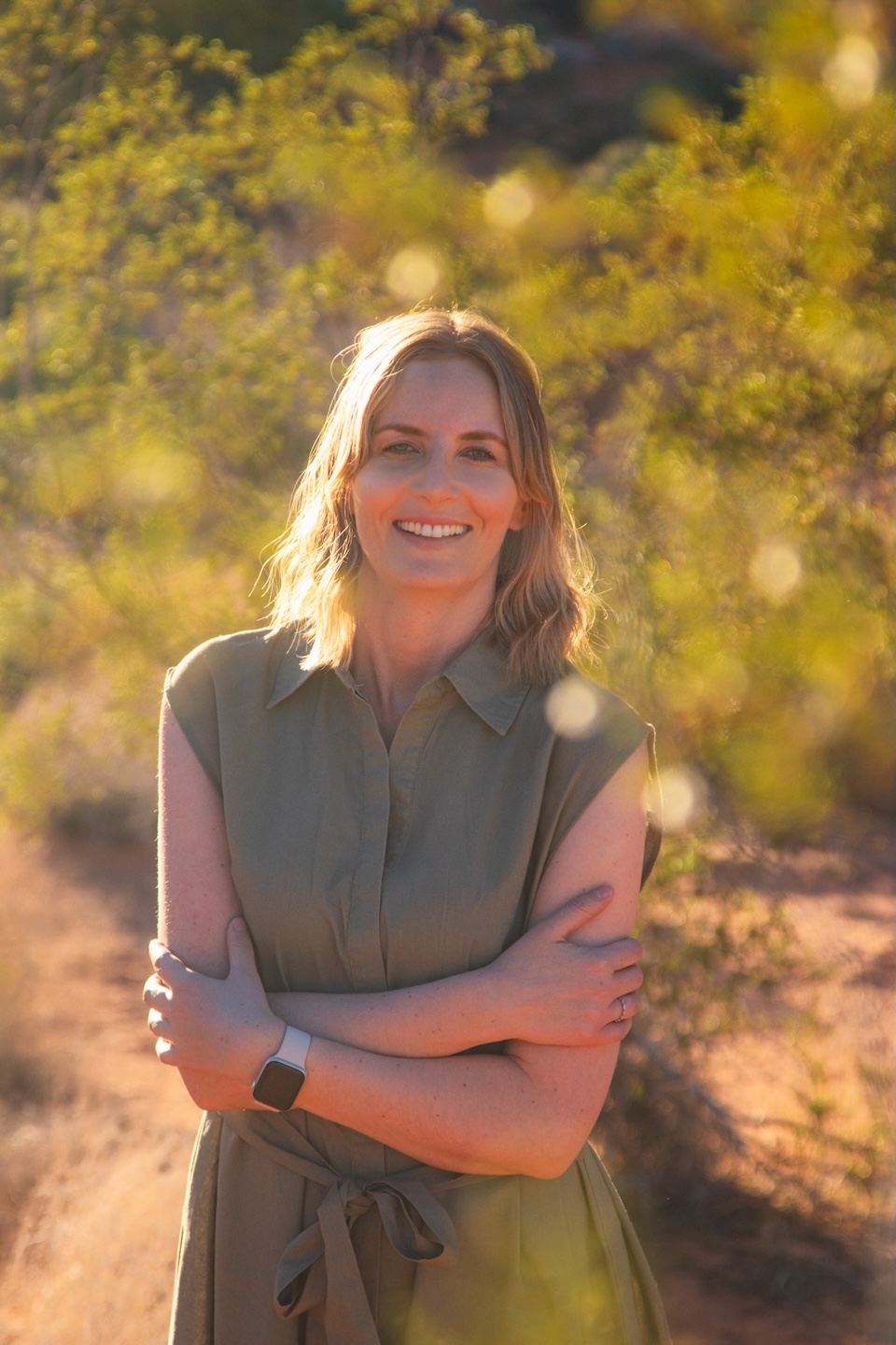Smiling woman in a green dress on a desert trail – profile photo of Runaway Ann