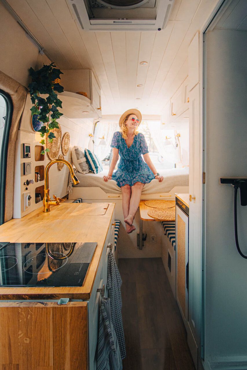 I'm sitting on the bed in our finished DIY campervan, now that the build is complete.