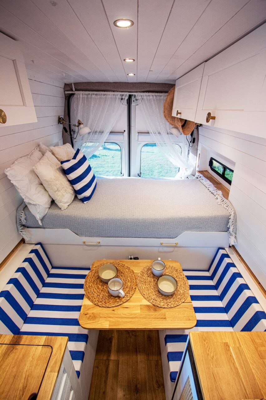 We’re sitting in our DIY camper with mugs in hand-the finished interior after the build.