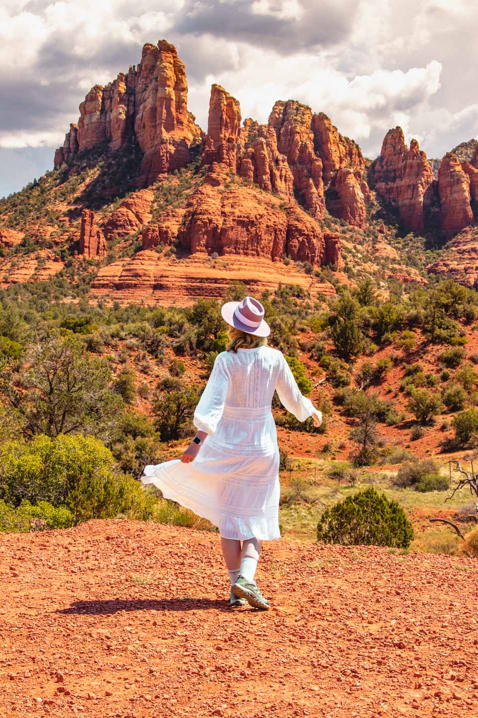 A woman against a backdrop of red rocks in Sedona during a peaceful road trip across the USA.