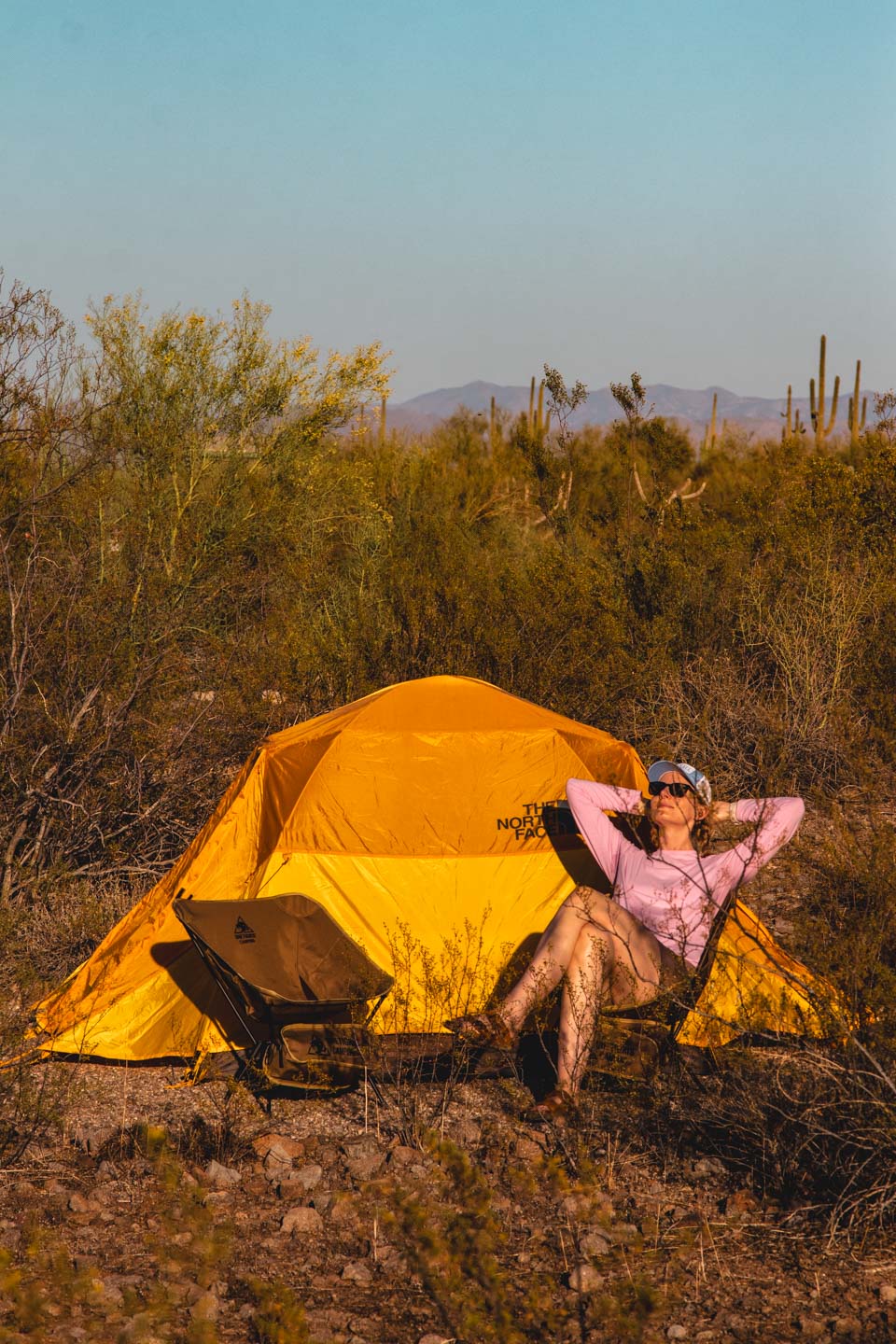 Relaxing by the tent in the desert during a peaceful road trip across the USA.